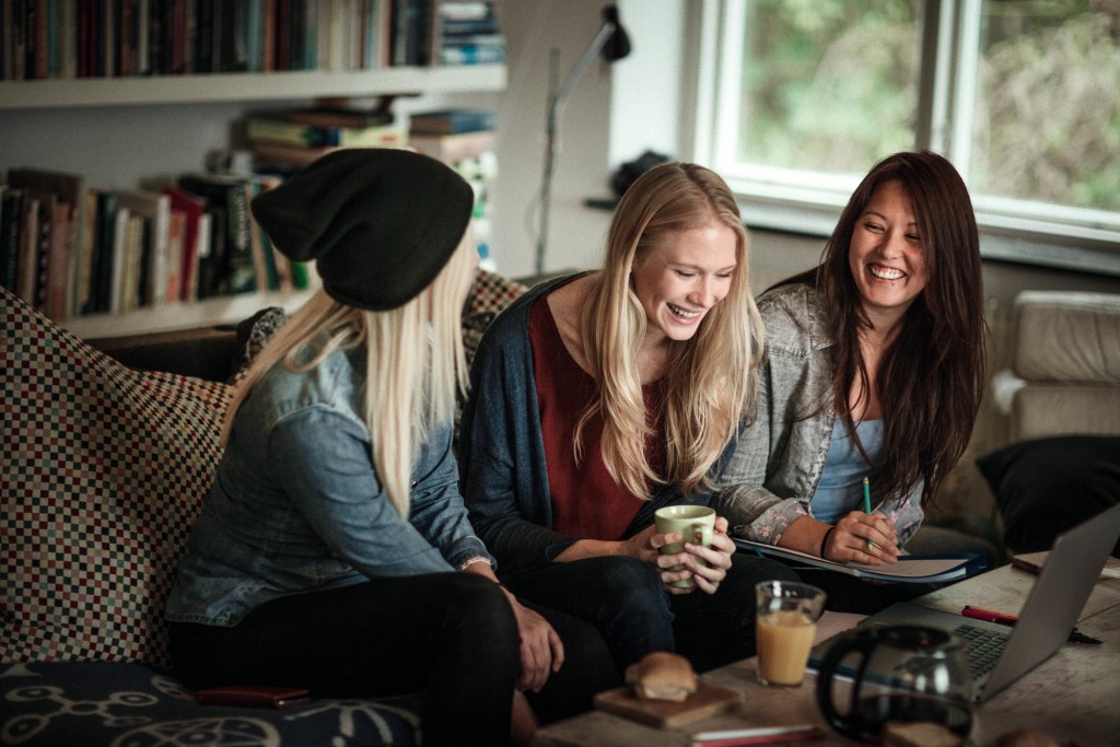 Three women sat on sofa talking